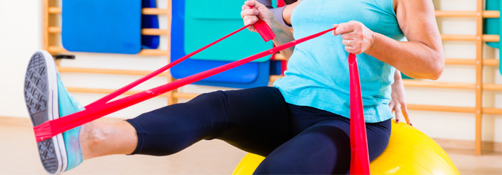 An individual using a thera-band for physical therapy exercises